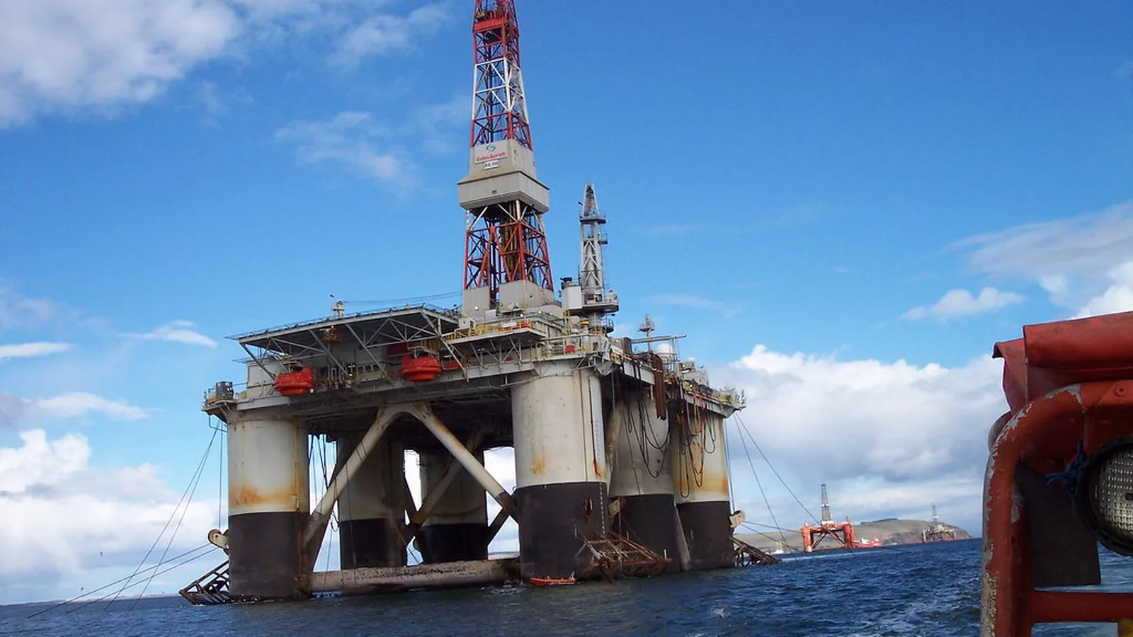 Offshore oil and gas drilling platform on open water under a clear sky